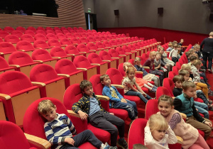 dzieci siedzą w sali teatralnej